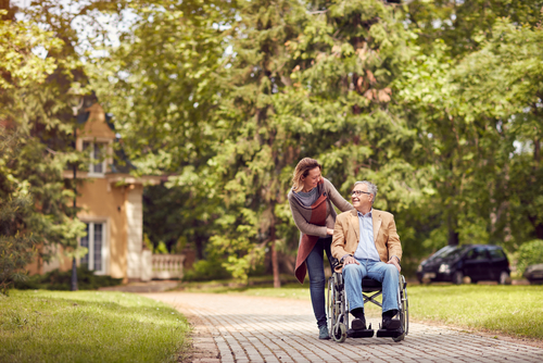 daughter senior man wheelchair walking