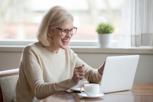 woman cheering at laptop