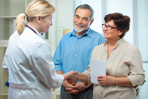 doctor shaking senior couples hands